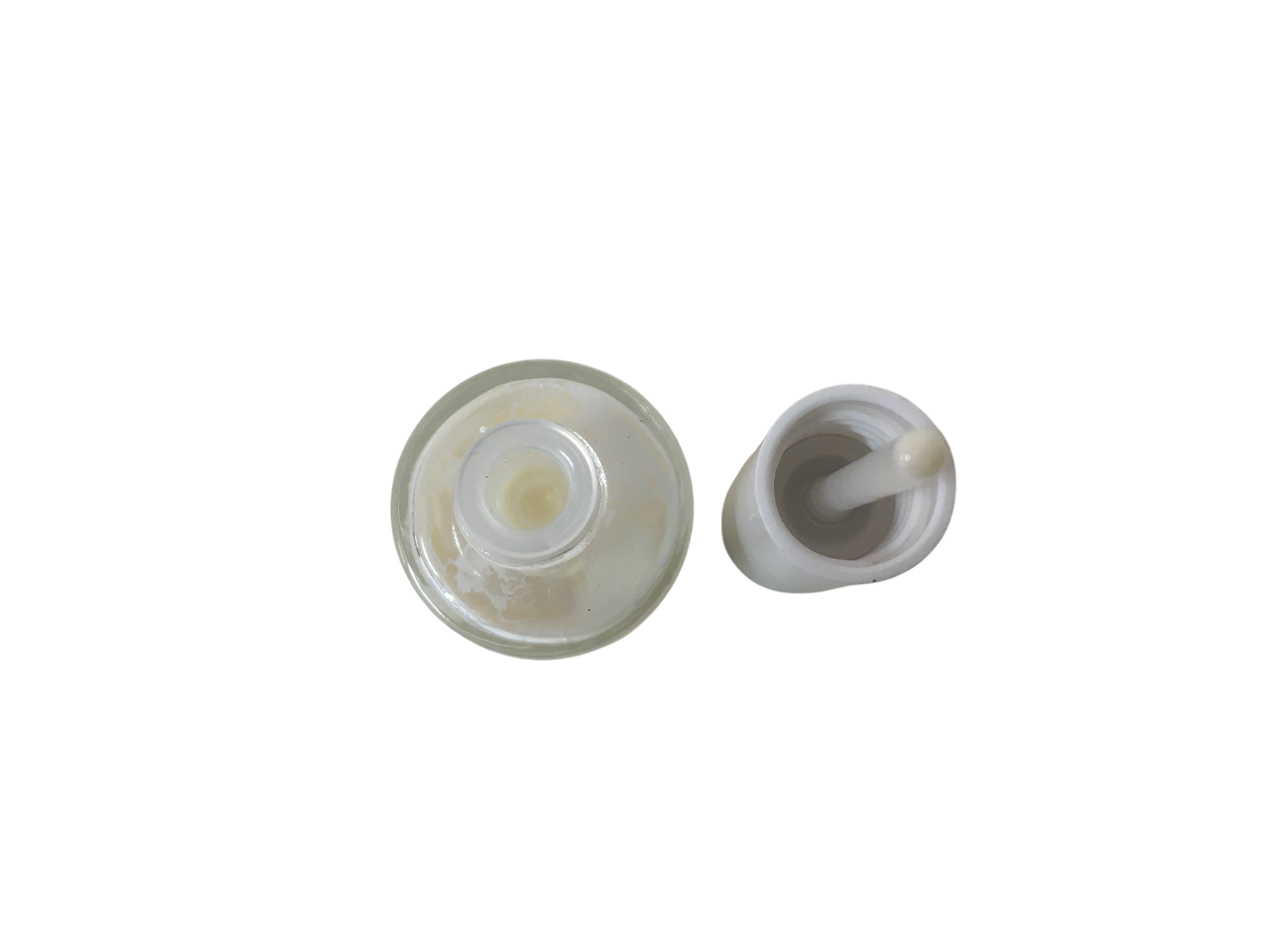 Vista dall'alto del flacone di smalto bianco e tappo con tampone