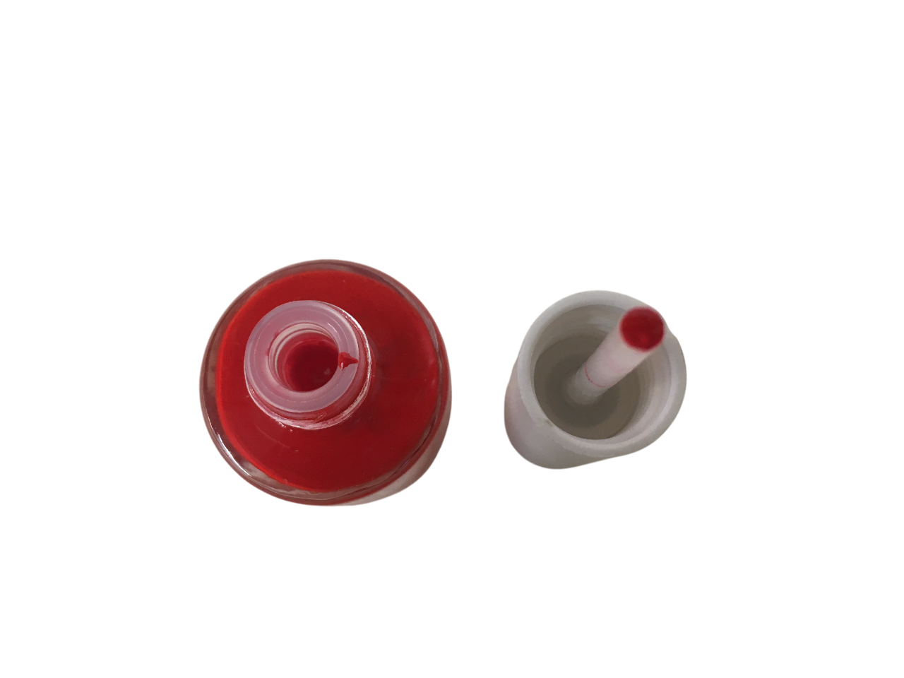 Vista dall'alto del flacone di smalto rosso e tappo con tampone